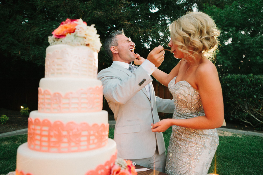 bride putting cake in grooms face