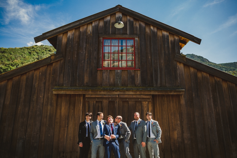 Groomsmen pose in front of barn at Redwood Ranch